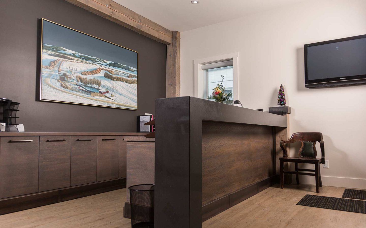 office reception area with large painting flat screen tv and chair